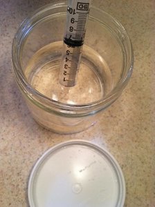 syringe in jar of liquid